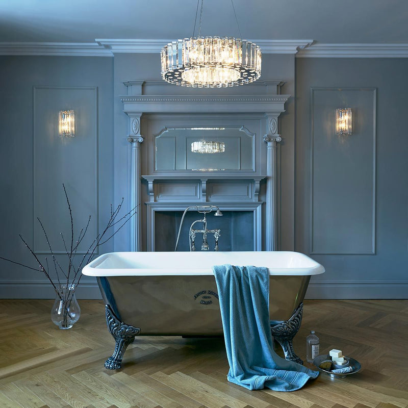 Luxurious bathroom with a freestanding bathtub, decorative towel, and elegant chandelier.